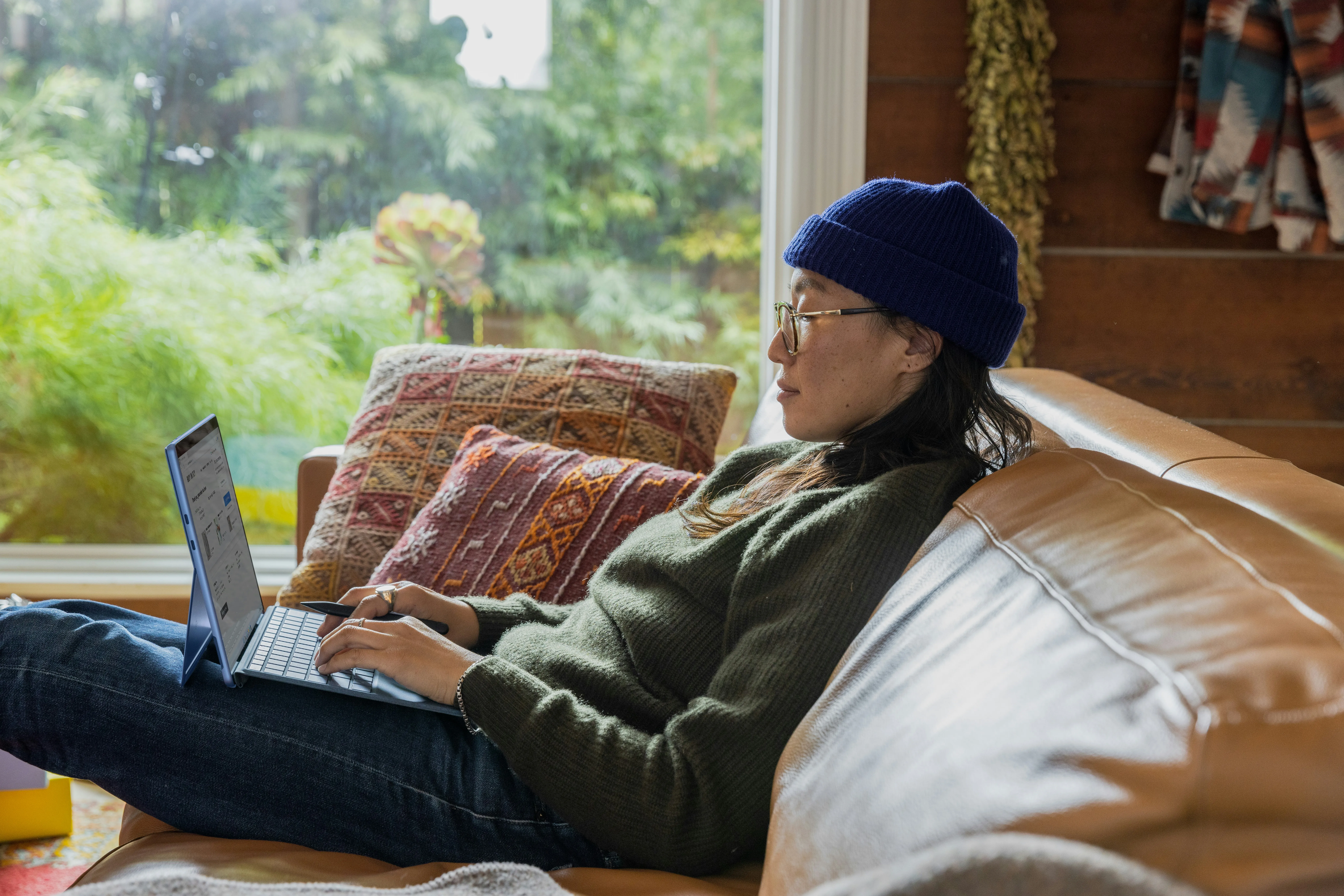 woman sat on sofa researching on her laptop