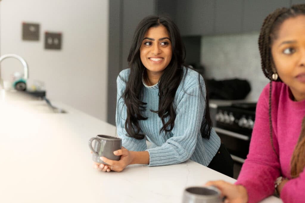 dietitians with a mug in hand, looking away from the camera smiling.