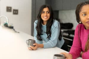 dietitians with a mug in hand, looking away from the camera smiling.