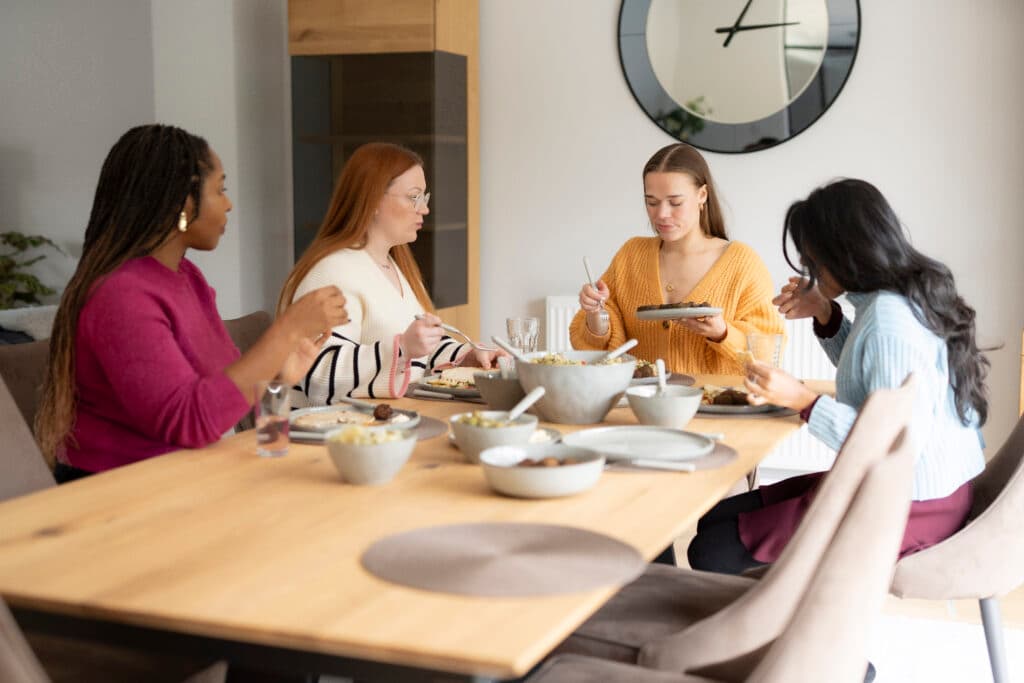 Group of dietitians sat around a table sharing a meal. Discussing disordered eating.