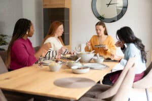 Group of dietitians sat around a table sharing a meal. Discussing disordered eating.